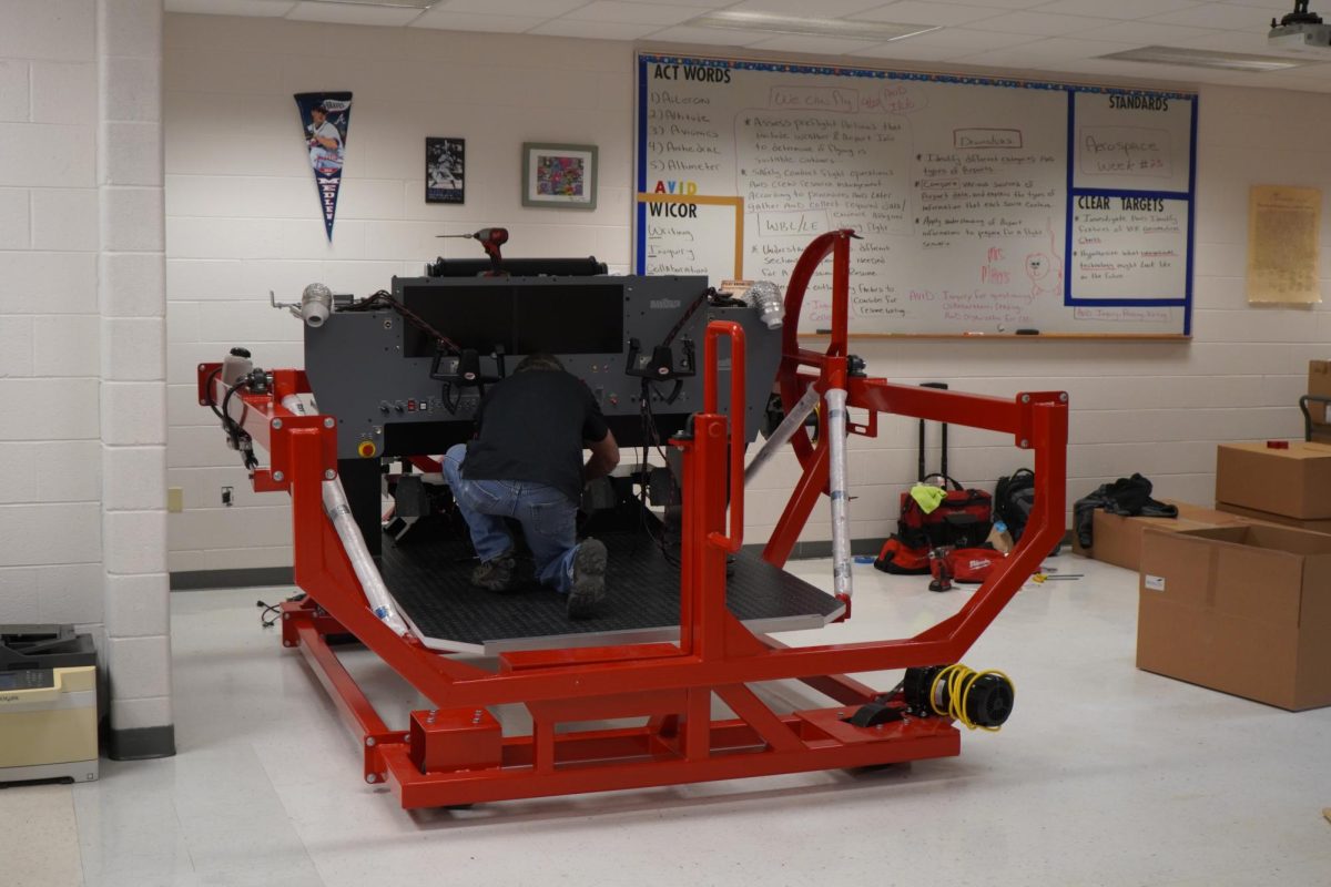 Workers put together the big flight simulator in Mr. Steffens' room.