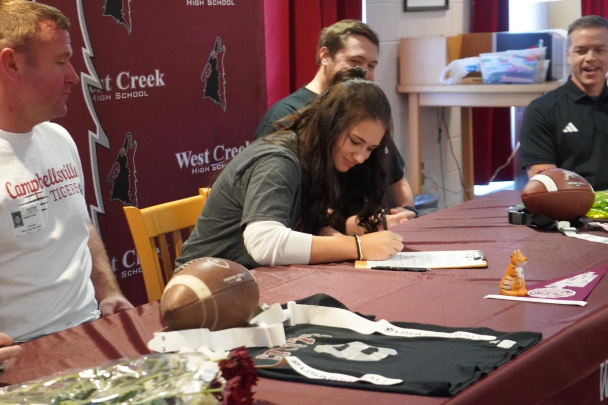 Kinleigh Lewis signs her letter-of-intent to play flag football for Campbellsville University on Dec. 11, 2024.