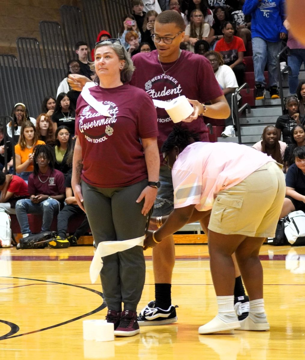 Ms. Schmucker get rolled in toilet paper during a contest at a pep rally on Aug. 30, 2024. Seniors Jayceon Rock and Makalya Rosser are doing the rolling.